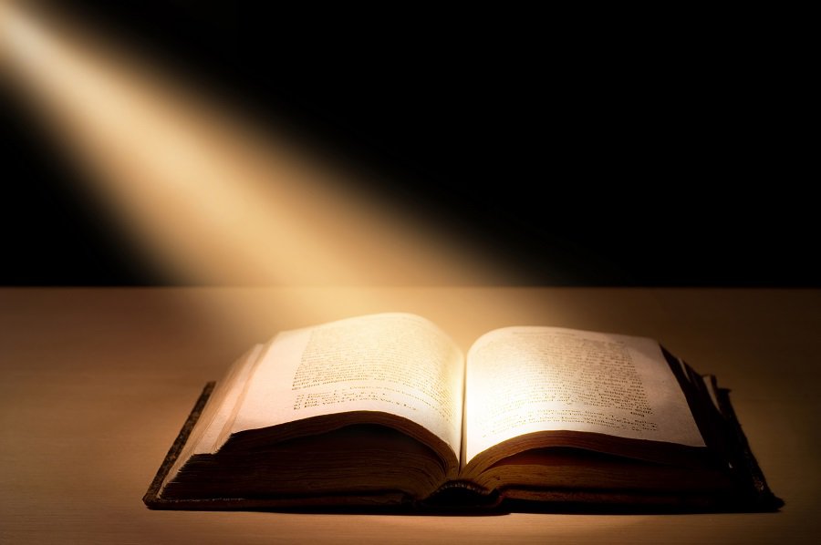 Bible Open with a ray of light illuminating it.